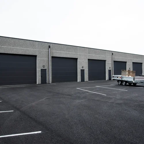 Industrigarasje med seks store garasjeporter og tre garasjedører i LOBAS PORTEN Eksklusiv Modern i farge sort.
