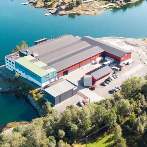Dronebilde av LOBAS PORTEN fabrikken beligende langs fjorden i Fotlandsvåg på Osterøy