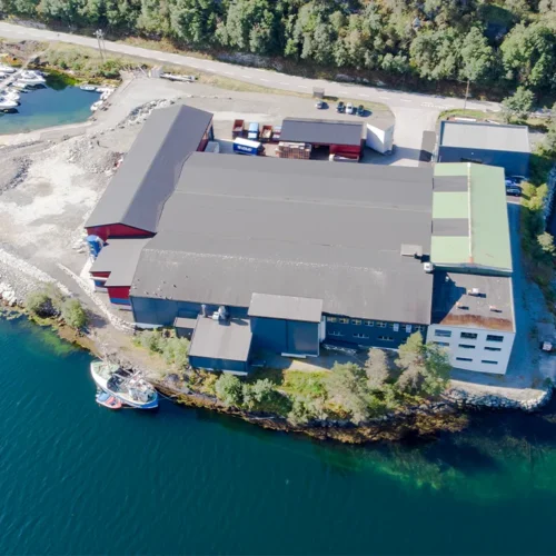 Dronebilde av LOBAS PORTEN fabrikken beligende langs fjorden i Fotlandsvåg på Osterøy