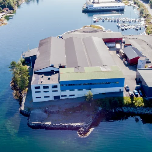 Dronebilde av LOBAS PORTEN fabrikken beligende langs fjorden i Fotlandsvåg på Osterøy