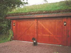 Garasje med to vippeporter med LOBAS PORTEN vippeportbeslag og en hund