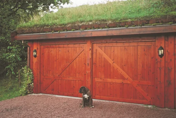Garasje med to vippeporter med LOBAS PORTEN vippeportbeslag og en hund